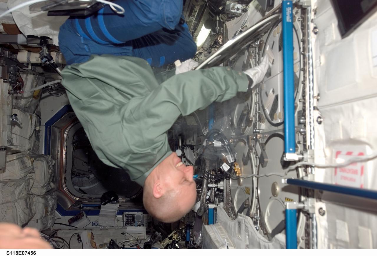 S118-E-07456 (13 Aug. 2007) --- Astronaut Clay Anderson, Expedition 15 flight engineer, works with the Minus Eighty Degree Laboratory Freezer for ISS (MELFI) in the Destiny laboratory of the International Space Station while Space Shuttle Endeavour (STS-118) remains docked with the station.