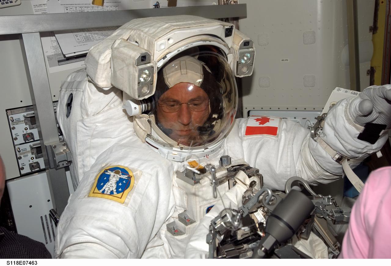 S118-E-07463 (13 Aug. 2007) --- Astronaut Dave Williams, STS-118 mission specialist representing the Canadian Space Agency, gets assistance from astronaut Tracy Caldwell (out of frame) as he prepares for extravehicular activity to work on the International Space Station. This will mark the second spacewalk for the Endeavour crew and the second for Williams in three days. He will again be joined by astronaut Rick Mastracchio for the EVA.