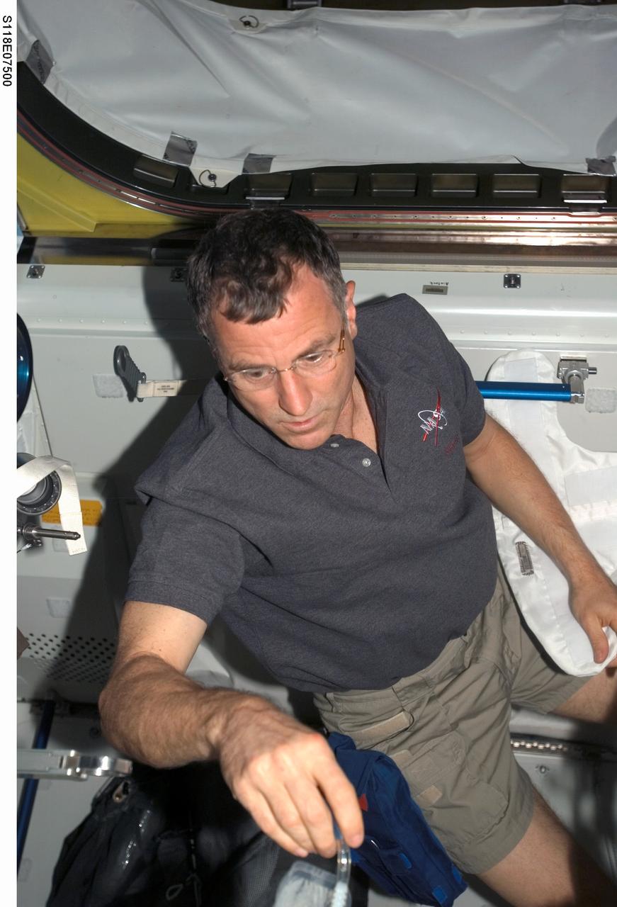 S118-E-07500 (14 Aug. 2007) --- Astronaut Dave Williams, STS-118 mission specialist representing the Canadian Space Agency, works in the Quest Airlock of the International Space Station while Space Shuttle Endeavour remains docked with the International Space Station.