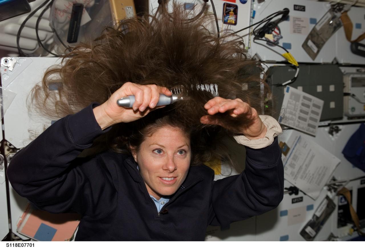 S118-E-07701 (17 Aug. 2007) --- Astronaut Tracy Caldwell, on the mid deck of the Space Shuttle Endeavour, brushes her hair as she prepares to participate in the shuttle crew's supply transfer chores. Tomorrow the mission specialist is scheduled to orchestrate the intravehicular support for the crew's final spacewalk, a role she has filled on three previous occasions on this her first space flight.