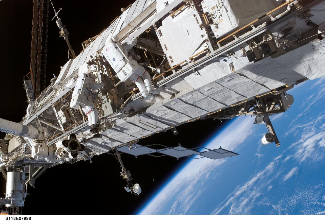 S118-E-07998 (15 Aug. 2007) --- Astronauts Rick Mastracchio (right), STS-118 mission specialist; and Clay Anderson, Expedition 15 flight engineer, participate in the mission's third planned session of extravehicular activity (EVA) as construction and maintenance continue on the International Space Station. During the 5-hour, 28-minute spacewalk, Mastracchio and Anderson relocated the S-Band Antenna Sub-Assembly from Port 6 (P6) to Port 1 (P1) truss, installed a new transponder on P1 and retrieved the P6 transponder. The blackness of space and Earth's horizon provide the backdrop for the scene.