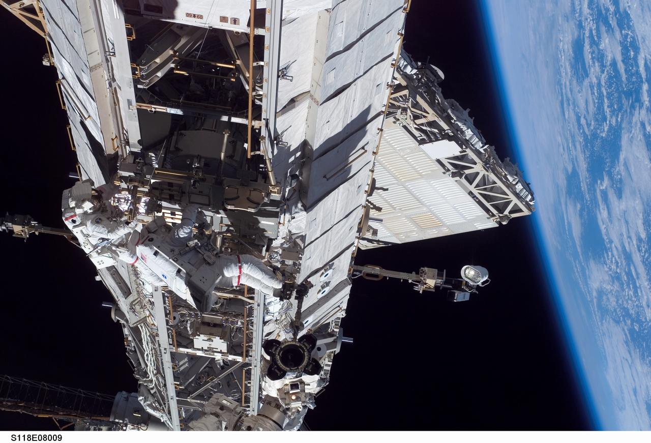 S118-E-08009 (15 Aug. 2007) --- Astronauts Rick Mastracchio (left), STS-118 mission specialist; and Clay Anderson, Expedition 15 flight engineer, participate in the mission's third planned session of extravehicular activity (EVA) as construction and maintenance continue on the International Space Station. During the 5-hour, 28-minute spacewalk, Mastracchio and Anderson relocated the S-Band Antenna Sub-Assembly from Port 6 (P6) to Port 1 (P1) truss, installed a new transponder on P1 and retrieved the P6 transponder. The blackness of space and Earth's horizon provide the backdrop for the scene.