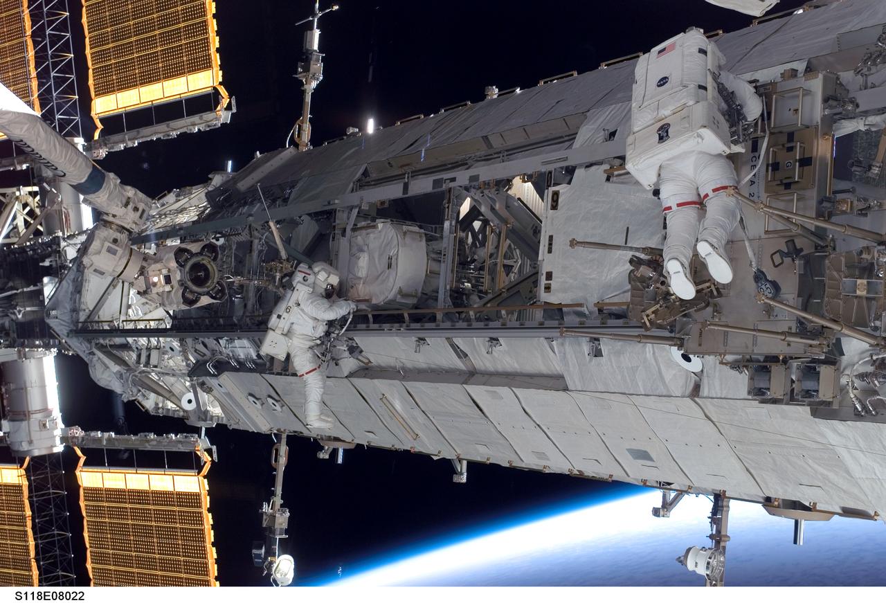 S118-E-08022 (15 Aug. 2007) --- Astronauts Clay Anderson (left), Expedition 15 flight engineer; and Rick Mastracchio, STS-118 mission specialist, participate in the mission's third planned session of extravehicular activity (EVA) as construction and maintenance continue on the International Space Station. During the 5-hour, 28-minute spacewalk, Mastracchio and Anderson relocated the S-Band Antenna Sub-Assembly from Port 6 (P6) to Port 1 (P1) truss, installed a new transponder on P1 and retrieved the P6 transponder. The blackness of space and Earth's horizon provide the backdrop for the scene.