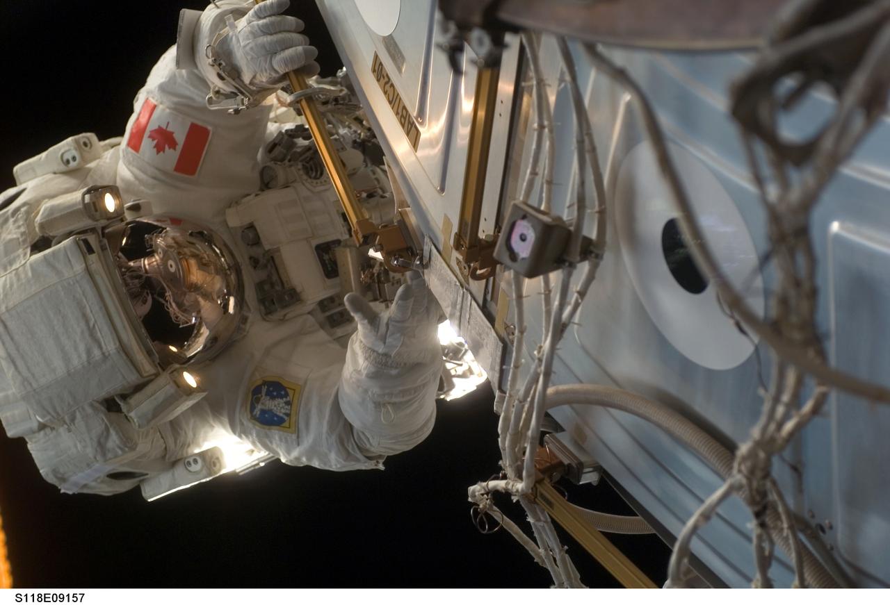 S118-E-09157 (18 Aug. 2007) --- Astronaut Dave Williams, STS-118 mission specialist representing the Canadian Space Agency, participates in the mission's fourth and final session of extravehicular activity (EVA) as construction and maintenance continue on the International Space Station. During the 5-hour spacewalk, Williams and astronaut Clay Anderson (out of frame), Expedition 15 flight engineer, installed the External Wireless Instrumentation System antenna, attached a stand for the shuttle's robotic arm extension boom and retrieved the two Materials International Space Station Experiments (MISSE) to be brought back on the shuttle.