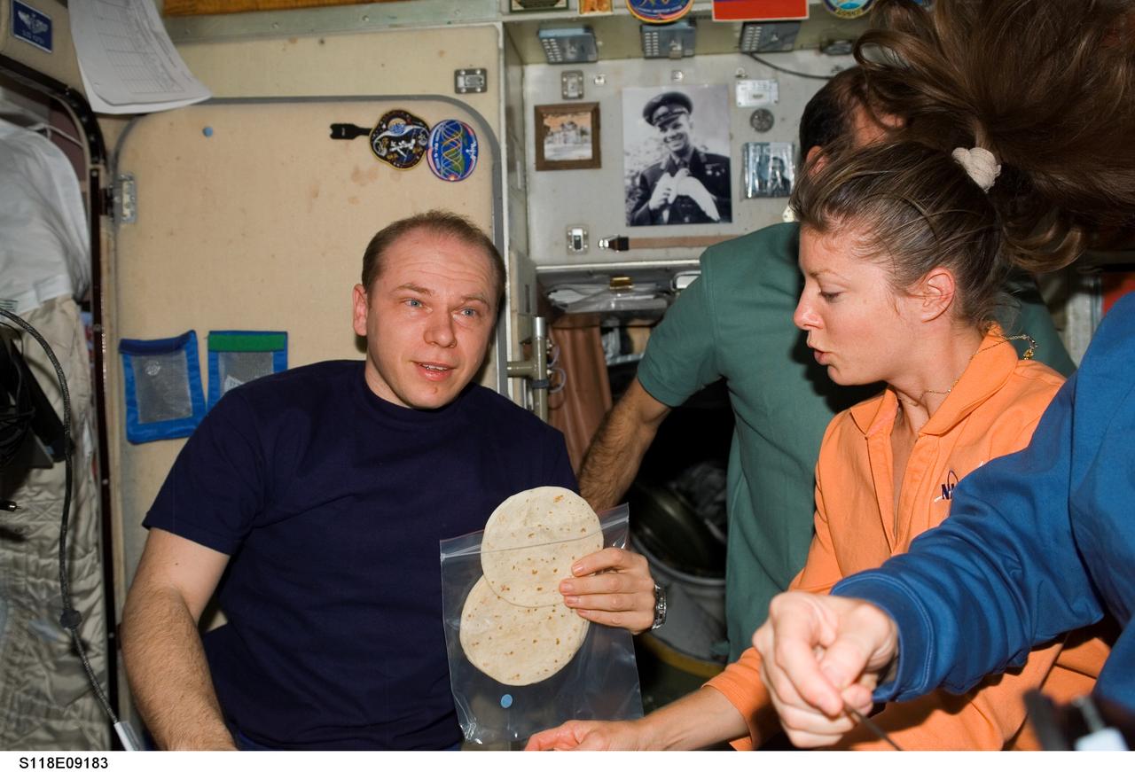 S118-E-09183 (18 Aug. 2007) --- The STS-118 and Expedition 15 crews share a meal during a farewell ceremony in the Zvezda Service Module of the International Space Station. Pictured are cosmonaut Oleg V. Kotov, Expedition 15 flight engineer representing Russia's Federal Space Agency; astronauts Rick Mastracchio (partially obscured) and Tracy Caldwell, both STS-118 mission specialists. Hatches were closed between the station and Space Shuttle Endeavour at 4:10 p.m. on Aug. 18.