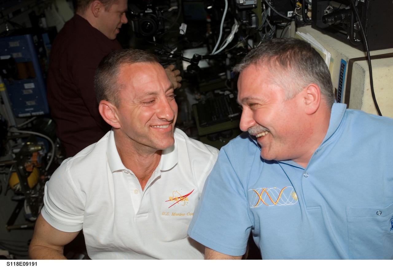 S118-E-09191 (18 Aug. 2007) --- Astronaut Charlie Hobaugh (left), STS-118 pilot, and cosmonaut Fyodor N. Yurchikhin, Expedition 15 commander representing Russia's Federal Space Agency, enjoy a light moment during a farewell ceremony in the Zvezda Service Module of the International Space Station. Hatches were closed between the station and Space Shuttle Endeavour at 4:10 p.m. on Aug. 18.