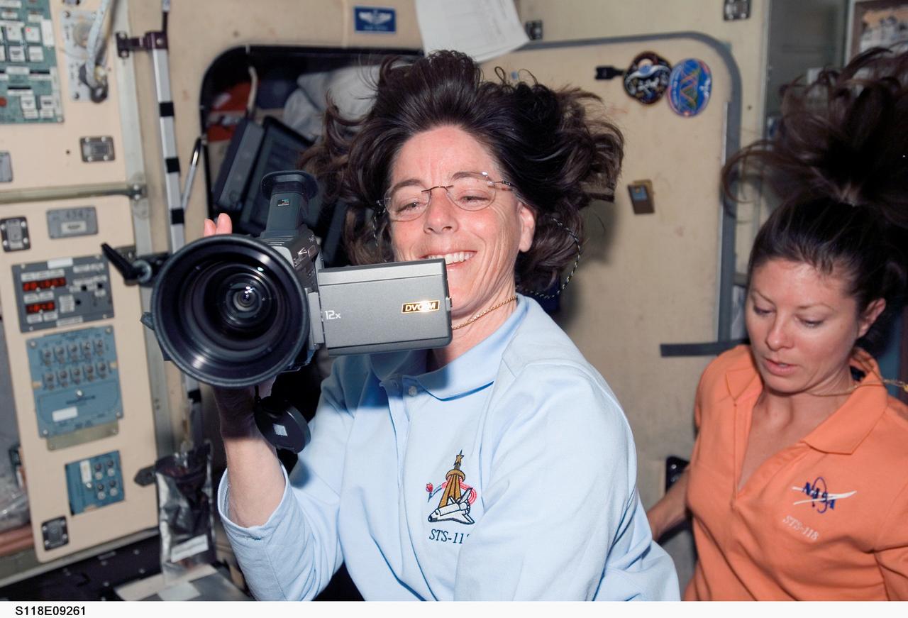 S118-E-09261 (18 Aug. 2007) --- Astronaut Barbara R. Morgan, STS-118 mission specialist, uses a video camera during a farewell ceremony in the Zvezda Service Module of the International Space Station. Astronaut Tracy Caldwell, mission specialist, is visible at right. Hatches were closed between the station and Space Shuttle Endeavour at 4:10 p.m. on Aug. 18.