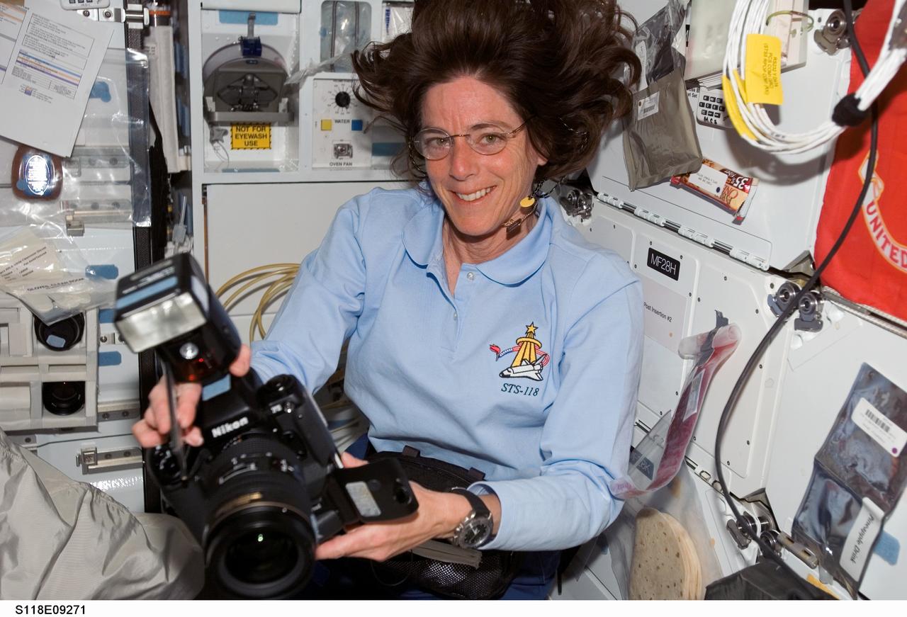 S118-E-09271 (18 Aug. 2007) --- Astronaut Barbara R. Morgan, STS-118 mission specialist, pauses for a photo while holding a still camera on the middeck of Space Shuttle Endeavour.