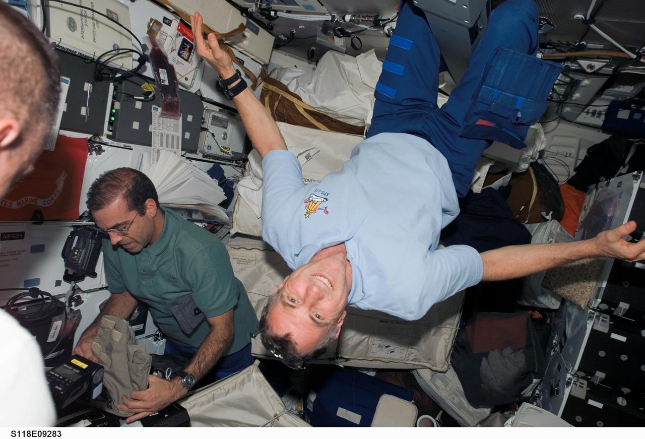 S118-E-09283 (18 Aug. 2007) --- Canadian Space Agency's astronaut Dave Williams (right), and astronaut Rick Mastracchio (left), both STS-118 mission specialists, along with Charlie Hobaugh (left, partially out of frame), pilot, work on the middeck of Space Shuttle Endeavour as the crew prepares for their return home. Hatches were closed between the International Space Station and Endeavour at 4:10 p.m. on Aug. 18.