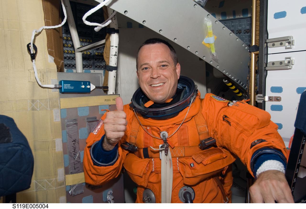 S119-E-005004 (15 March 2009) --- Astronaut Richard Arnold, STS-119 mission specialist, attired in his shuttle launch and entry suit, gives a “thumbs-up” signal on the middeck of Space Shuttle Discovery during postlaunch activities.