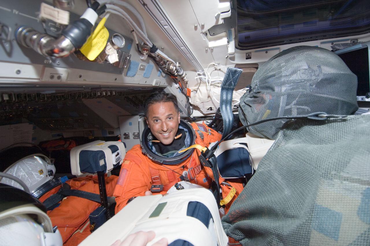 S119-E-005007 (15 March 2009) --- Astronaut Joseph Acaba, STS-119 mission specialist, attired in his shuttle launch and entry suit, works on the flight deck of Space Shuttle Discovery during postlaunch activities.