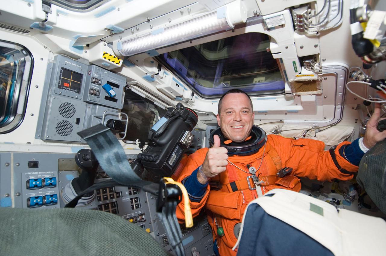 S119-E-005010 (15 March 2009) --- Astronaut Richard Arnold, STS-119 mission specialist, attired in his shuttle launch and entry suit, gives a “thumbs-up” signal on the aft flight deck of Space Shuttle Discovery during postlaunch activities.