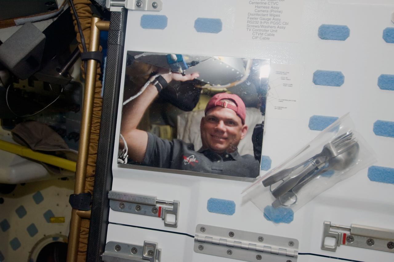 S119-E-006183 (16 March 2009) --- Astronaut Tony Antonelli, STS-119 pilot, is pictured in the reflection of a mirror on the middeck of Space Shuttle Discovery during flight day two activities.