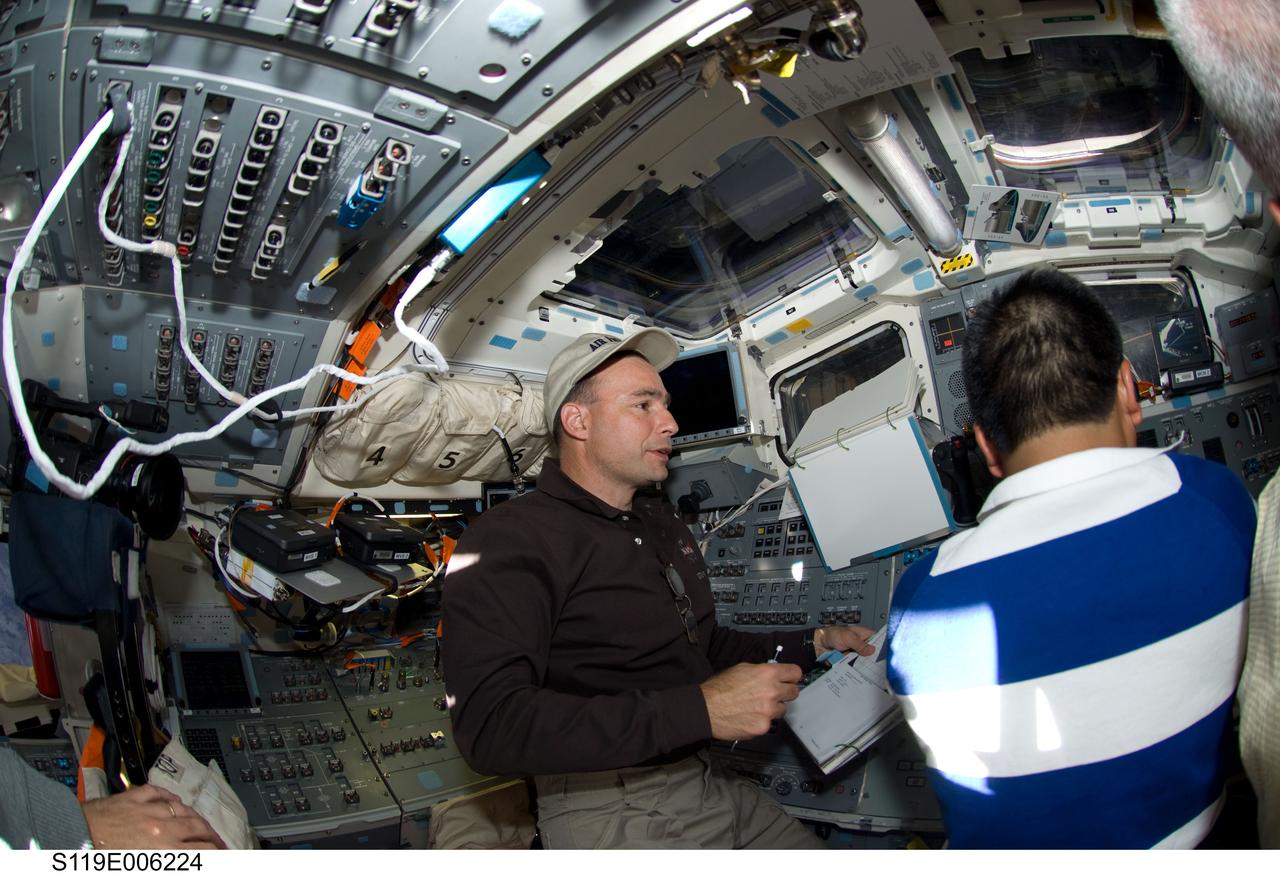 S119-E-006224 (16 March 2009) --- Astronaut Lee Archambault (left), STS-119 commander, and Japan Aerospace Exploration Agency (JAXA) astronaut Koichi Wakata, mission specialist, are pictured on the aft flight deck of Space Shuttle Discovery during flight day two activities.