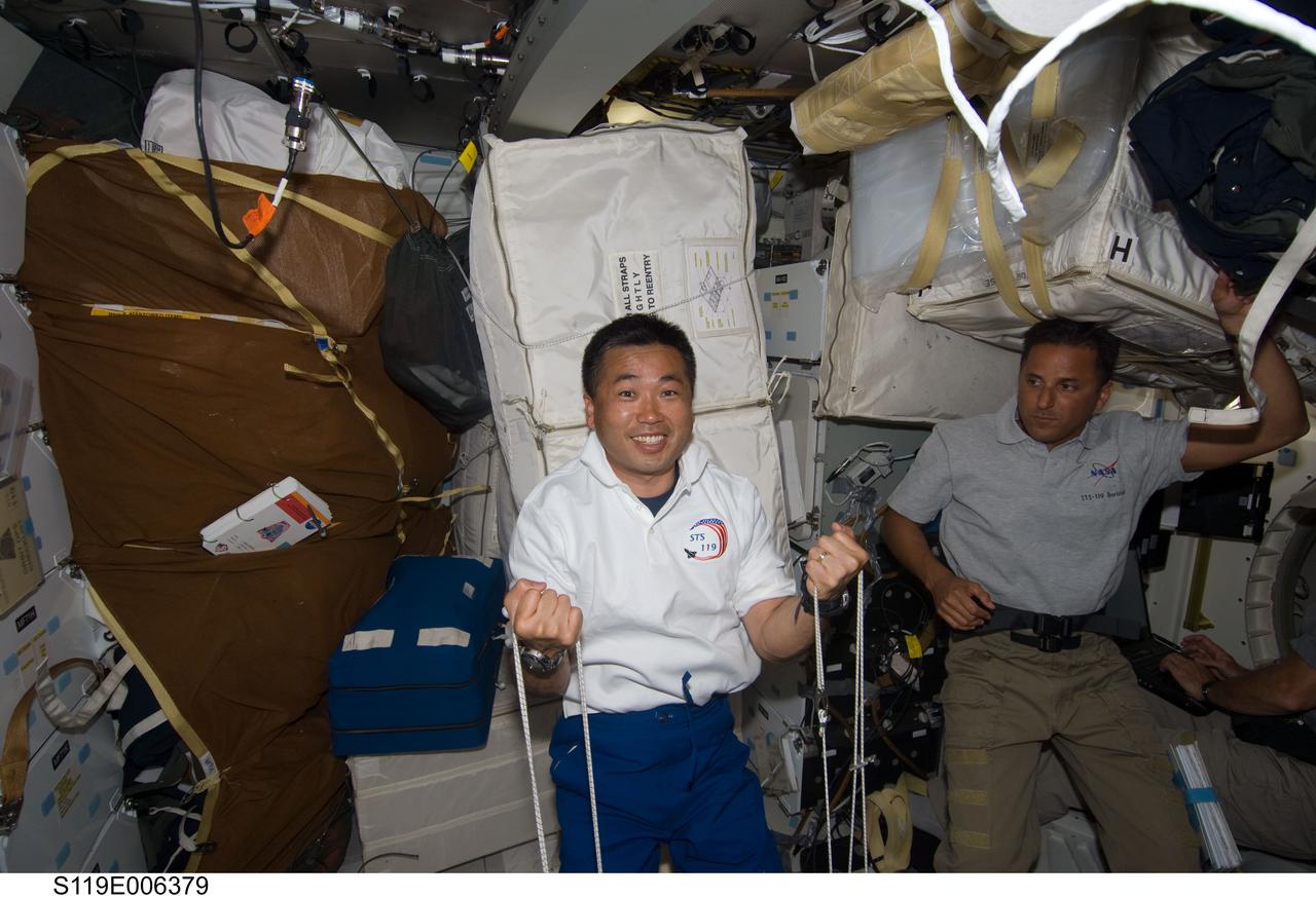 S119-E-006379 (17 March 2009) --- Japan Aerospace Exploration Agency (JAXA) astronaut Koichi Wakata, STS-119 mission specialist, exercises on the middeck of Space Shuttle Discovery during flight day three activities. Astronaut Joseph Acaba, mission specialist, is at right.