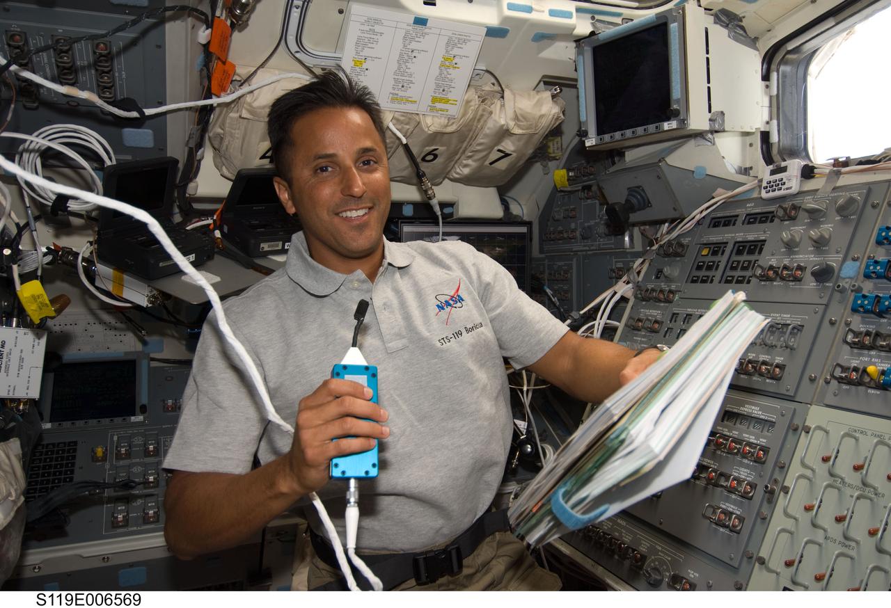 S119-E-006569 (18 March 2009) --- Astronaut Joseph Acaba, STS-119 mission specialist, uses a communication system on the aft flight deck of Space Shuttle Discovery while docked with the International Space Station.