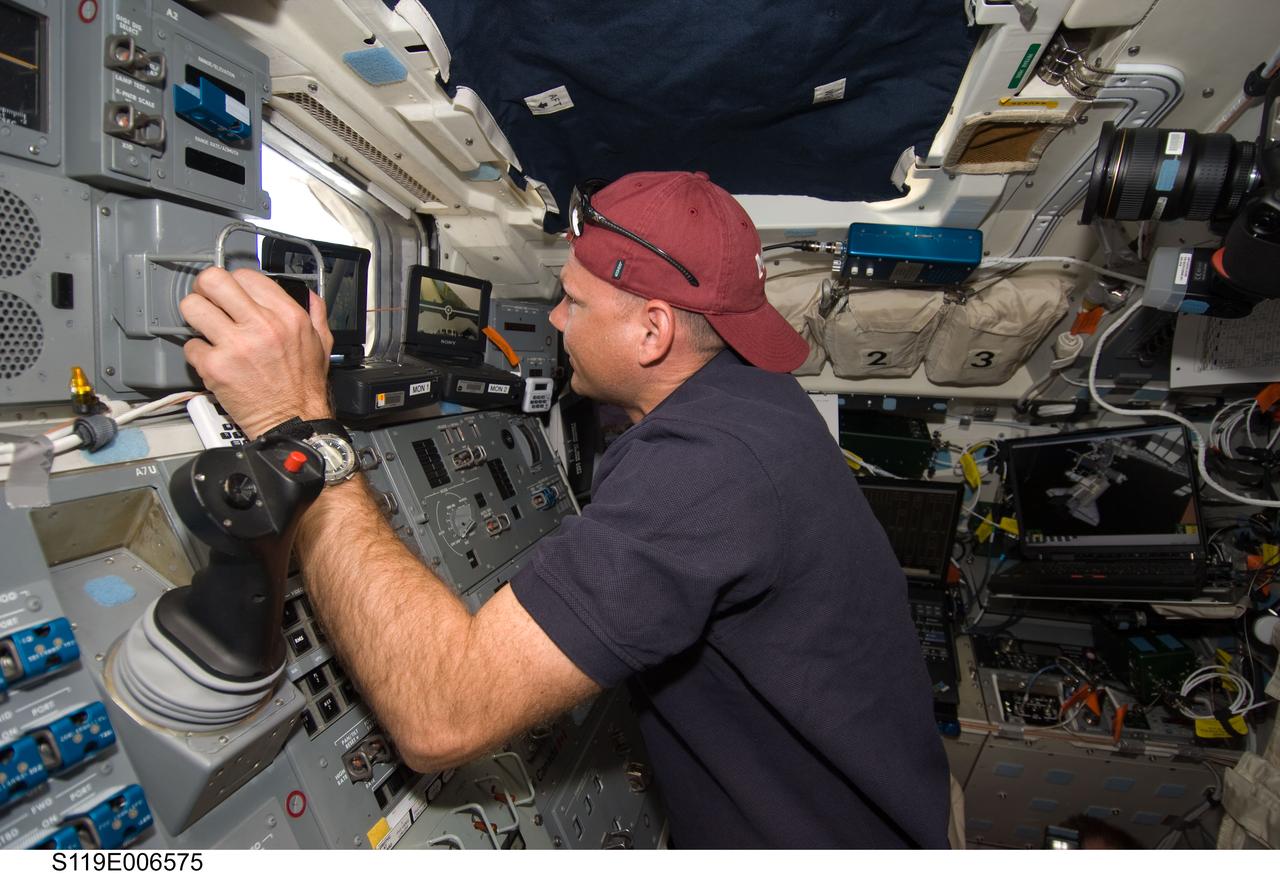 S119-E-006575 (18 March 2009) --- Astronaut Tony Antonelli, STS-119 pilot, works controls on the aft flight deck of Space Shuttle Discovery while docked with the International Space Station.