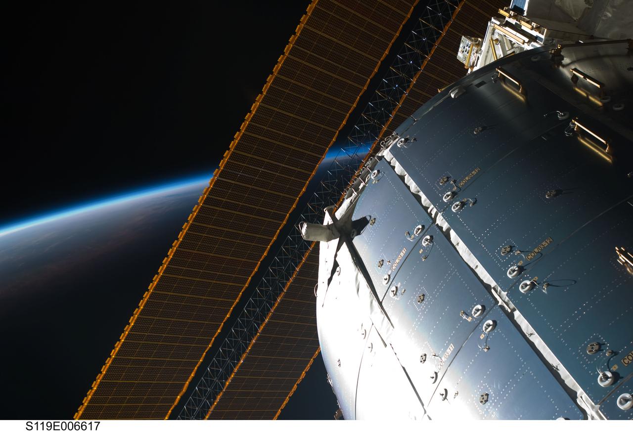 S119-E-006617 (18 March 2009) --- Backdropped by the blackness of space and Earth’s atmosphere, a portion of the International Space Station’s Columbus laboratory and solar array panels are featured in this image photographed by a STS-119 crewmember while Space Shuttle Discovery is docked with the station.