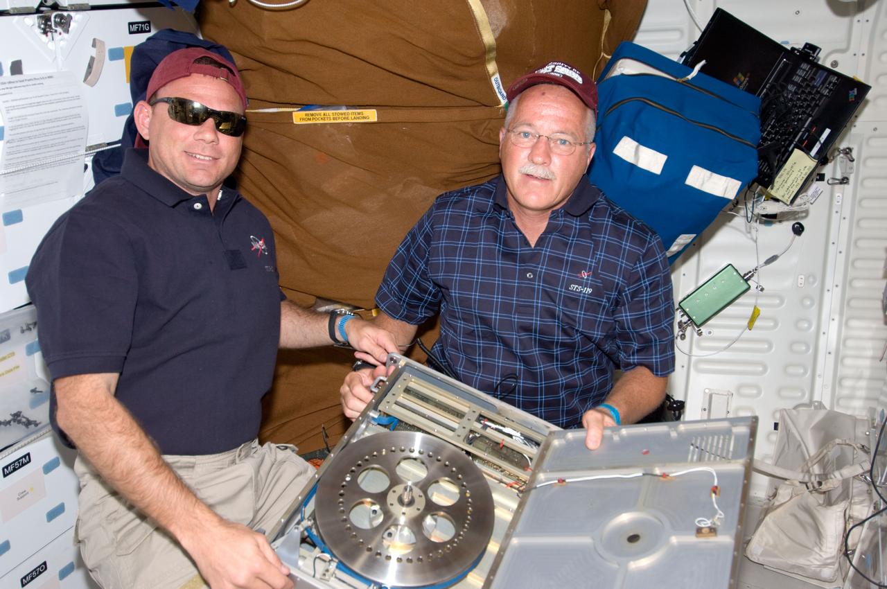 S119-E-006662 (19 March 2009) --- Astronauts Tony Antonelli (left), STS-119 pilot; and John Phillips, mission specialist, pose for a photo on the middeck of Space Shuttle Discovery while docked with the International Space Station.