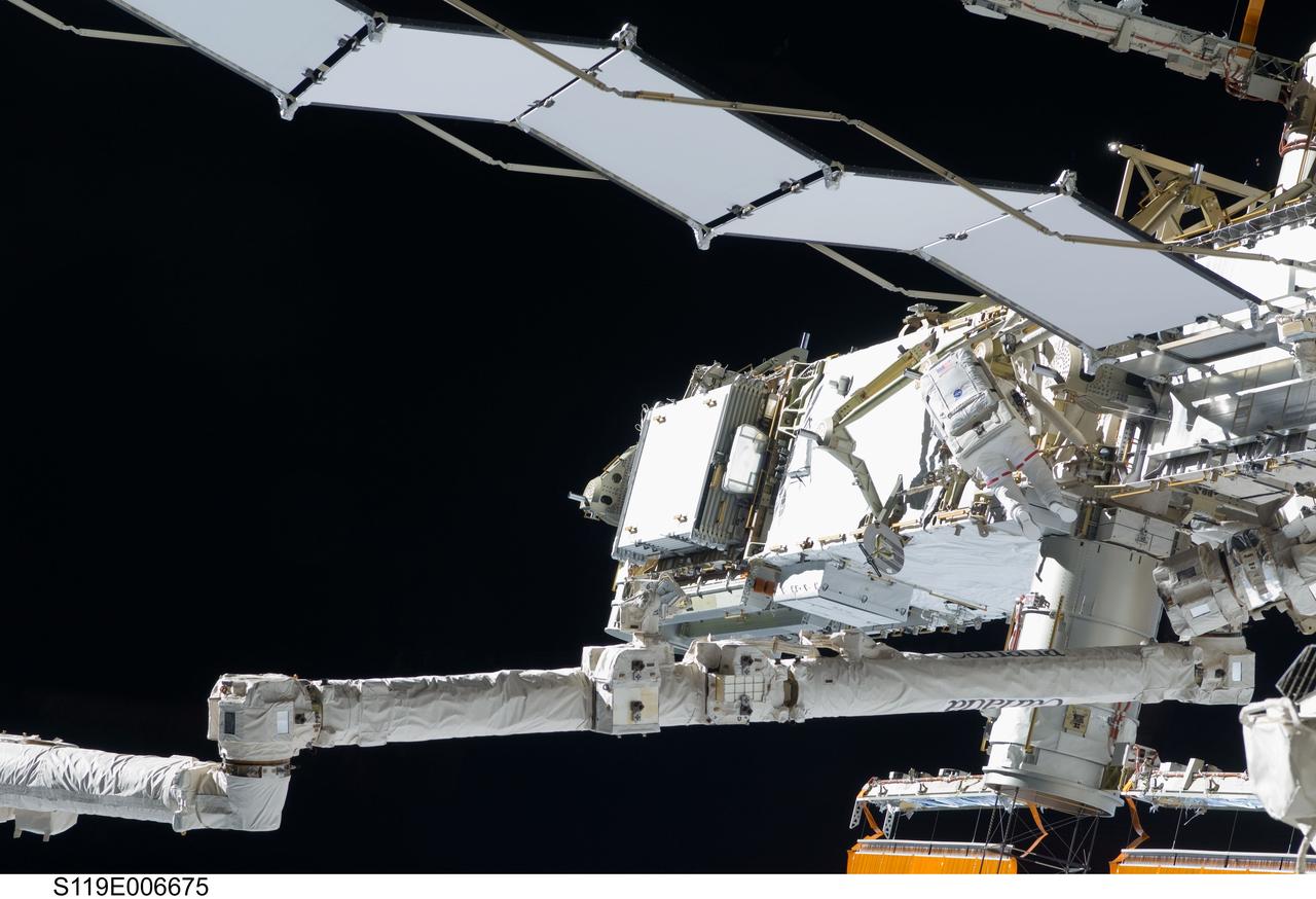 S119-E-006675 (19 March 2009) --- Astronaut Steve Swanson (center right), STS-119 mission specialist, participates in the mission's first scheduled session of extravehicular activity (EVA) as construction and maintenance continue on the International Space Station. During the six-hour, seven-minute spacewalk, Swanson and astronaut Richard Arnold (out of frame), mission specialist, connected bolts to permanently attach the S6 truss segment to S5. The spacewalkers plugged in power and data connectors to the truss, prepared a radiator to cool it, opened boxes containing the new solar arrays and deployed the Beta Gimbal Assemblies containing masts that support the solar arrays.