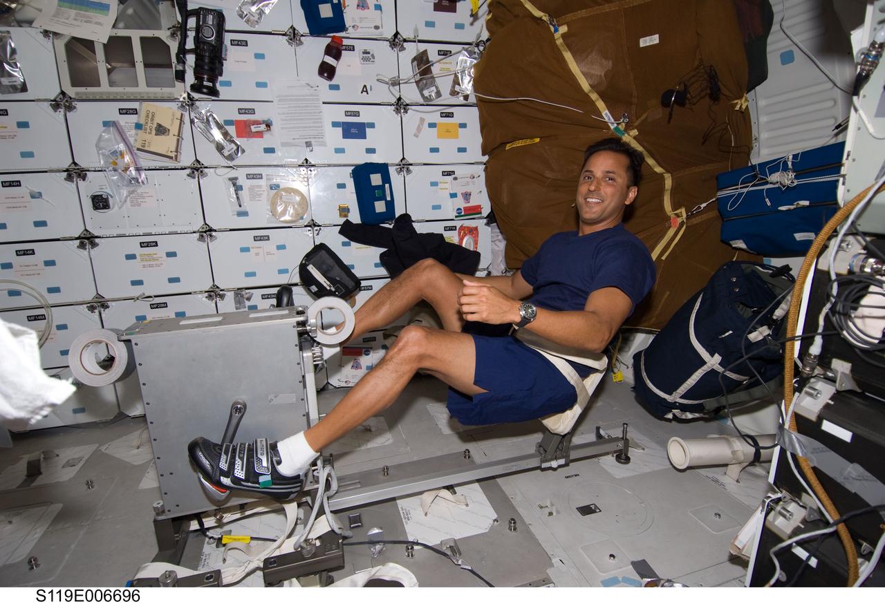 S119-E-006696 (20 March 2009) --- Astronaut Joseph Acaba, STS-119 mission specialist, uses the bicycle ergometer on Discovery's mid deck to get some exercise.