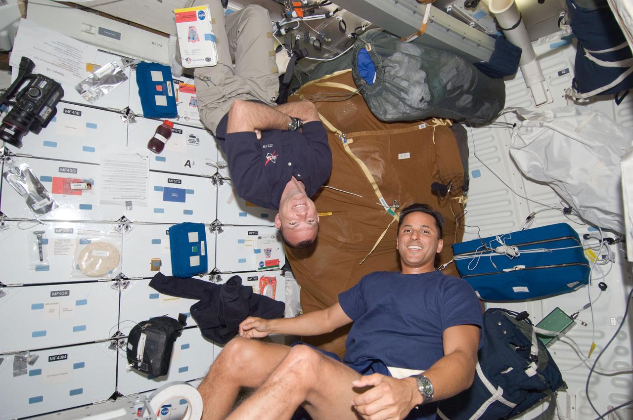 S119-E-006712 (20 March 2009) --- Astronaut Tony Antonelli (left), Discovery pilot,  almost appears to be saying "I've got next" as he hovers over an exercising astronaut Joseph Acaba. The STS-119 mission specialist is working out on the bicycle ergometer which the crew earlier deployed on the floor of Discovery's middeck. While Acaba goes outside the International Space Station on March 21 to participate in a spacewalk, Antonelli will remain inside to contribute support, along with other astronauts and a Russian cosmonaut.