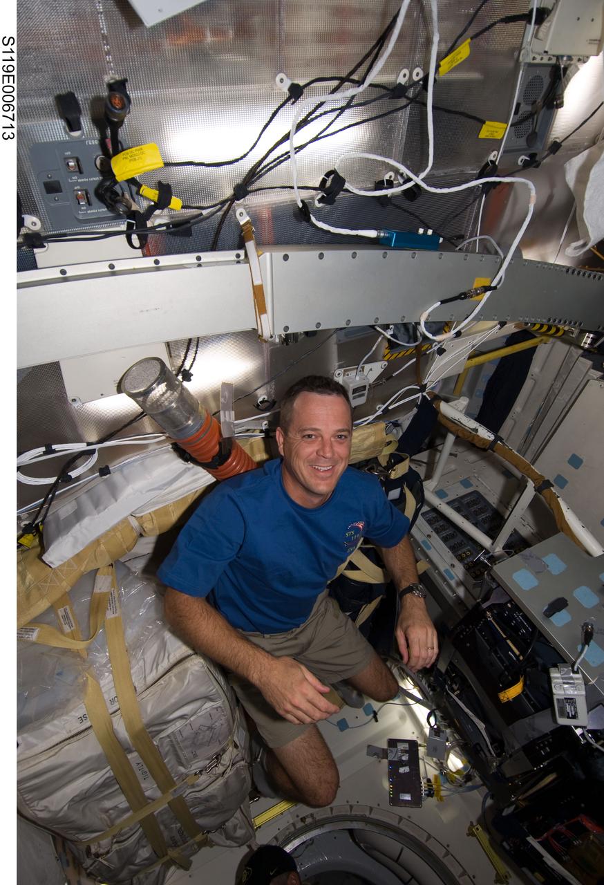 S119-E-006713 (20 March 2009) --- Astronaut Richard Arnold, STS-119 mission specialist,  almost appears to be suspended from the "ceiling" of Discovery's mid deck as he completes a flight day six task.