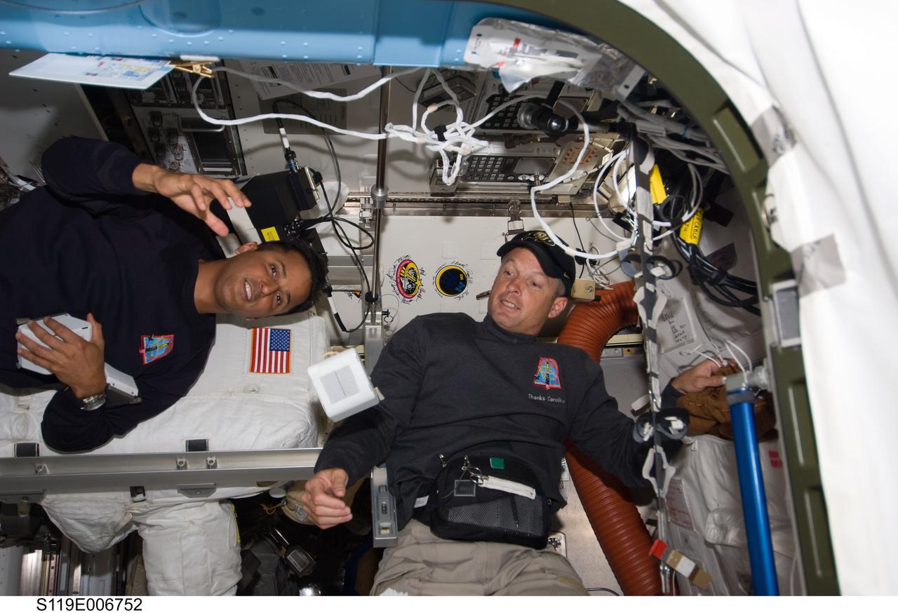 S119-E-006752 (20 March 2009) ---  Astronauts Joseph Acaba and Steve Swanson, both mission specialists, are pictured near the robotic workstation in Destiny or the U.S. laboratory within 24 hours of their planned spacewalk, scheduled for March 21