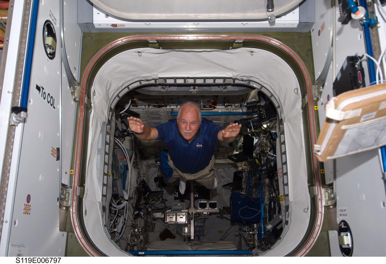S119-E-006797 (20 March 2009) --- Astronaut John Phillips is about to exit the European Space Agency's Columbus module in a manner quite unique to space travelers. The STS-119 mission specialist and the rest of the Discovery crew are joining forces with the Expedition 18 crew for the continuation of the home improvement project aboard the International Space Station.