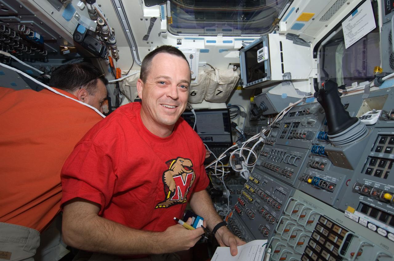 S119-E-006942 (21 March 2009) --- Astronaut Richard Arnold, STS-119 mission specialist, smiles for a photo while working on the aft flight deck of Space Shuttle Discovery while docked with the International Space Station. Astronaut Lee Archambault, commander, is at left.
