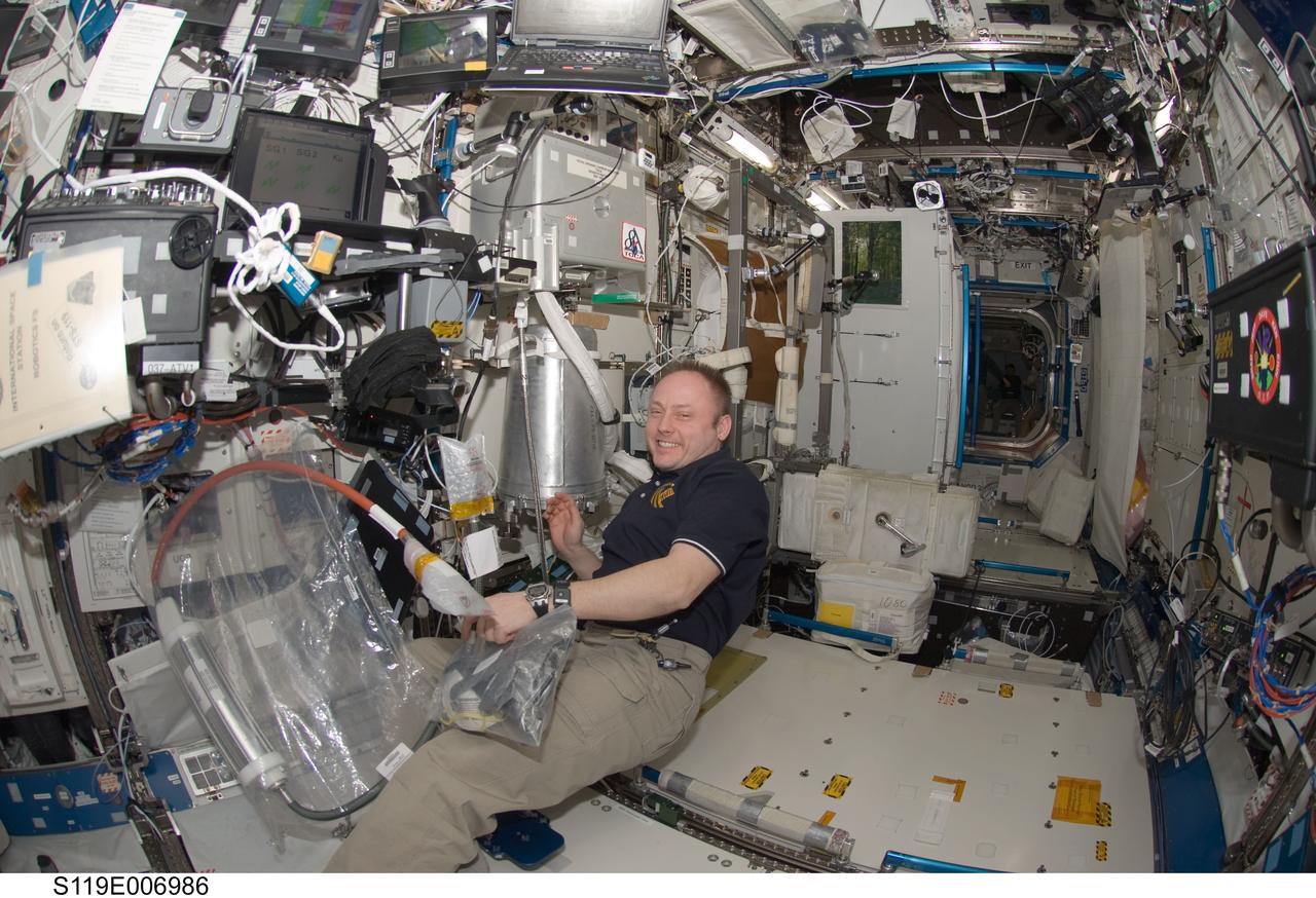 S119-E-006986 (22 March 2009) --- Astronaut Michael Fincke, Expedition 18 commander, works in the Destiny laboratory of the International Space Station while Space Shuttle Discovery (STS-119) is docked with the station.