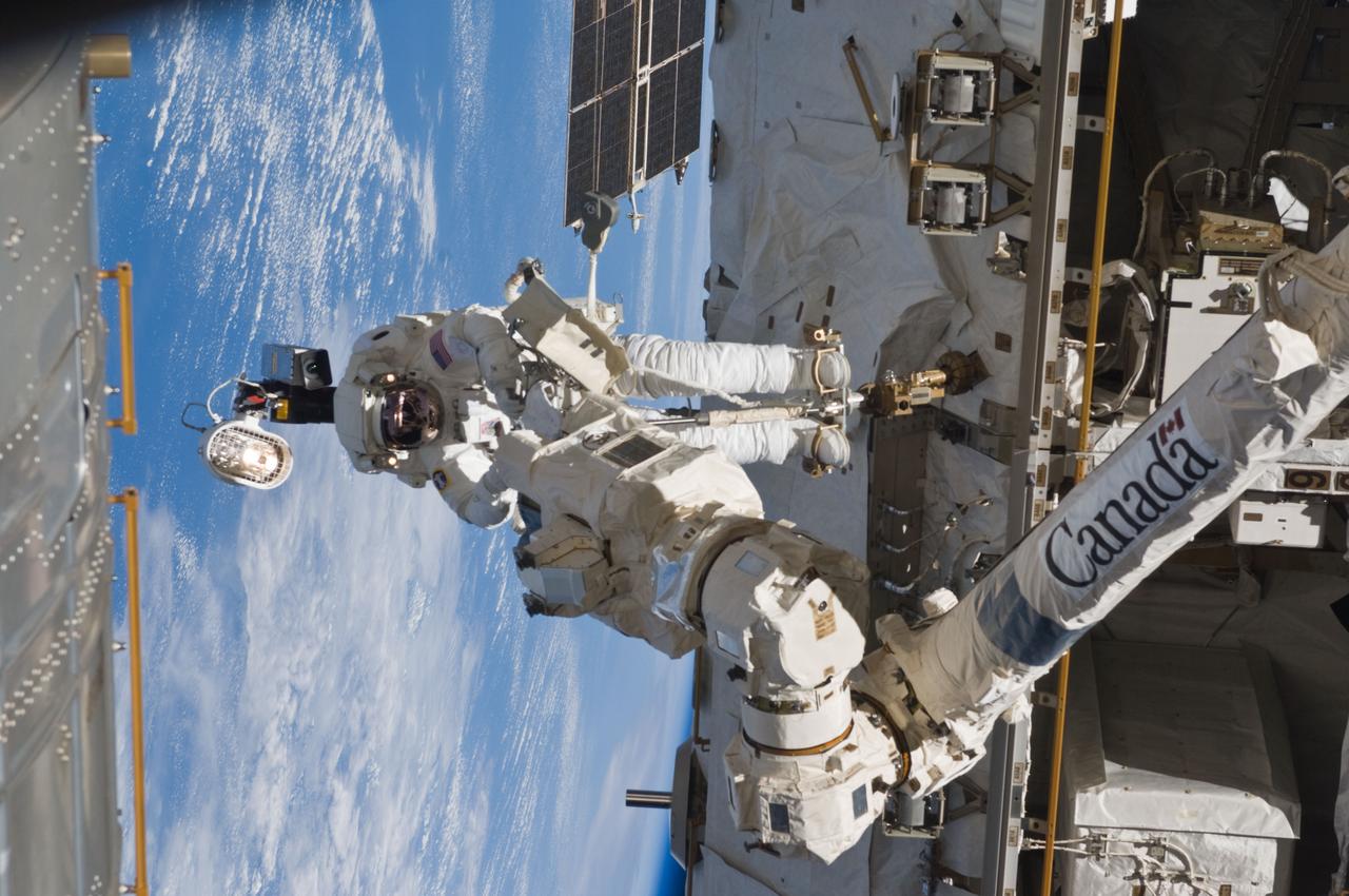 S119-E-007105 (23 March 2009) --- Astronaut Richard Arnold, STS-119 mission specialist, participates in the mission's third scheduled session of extravehicular activity (EVA) as construction and maintenance continue on the International Space Station. During the six-hour, 27-minute spacewalk, Arnold and Joseph Acaba (out of frame), mission specialist, helped robotic arm operators relocate the Crew Equipment Translation Aid (CETA) cart from the Port 1 to Starboard 1 truss segment, installed a new coupler on the CETA cart, lubricated snares on the "B" end of the space station's robotic arm and performed a few "get ahead" tasks.