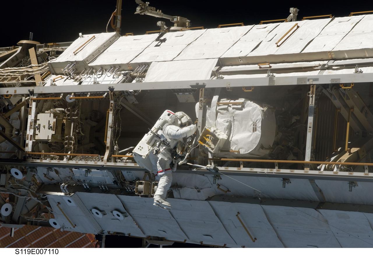 S119-E-007110 (23 March 2009) --- Astronaut Joseph Acaba, STS-119 mission specialist, participates in the mission's third scheduled session of extravehicular activity (EVA) as construction and maintenance continue on the International Space Station. During the six-hour, 27-minute spacewalk, Acaba and Richard Arnold (out of frame), mission specialist, helped robotic arm operators relocate the Crew Equipment Translation Aid (CETA) cart from the Port 1 to Starboard 1 truss segment, installed a new coupler on the CETA cart, lubricated snares on the "B" end of the space station's robotic arm and performed a few "get ahead" tasks.
