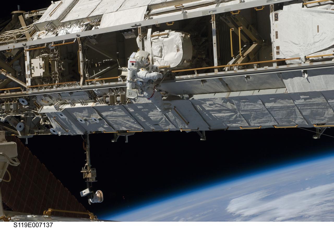 S119-E-007137 (23 March 2009) --- Astronaut Joseph Acaba, STS-119 mission specialist, participates in the mission's third scheduled session of extravehicular activity (EVA) as construction and maintenance continue on the International Space Station. During the six-hour, 27-minute spacewalk, Acaba and Richard Arnold (out of frame), mission specialist, helped robotic arm operators relocate the Crew Equipment Translation Aid (CETA) cart from the Port 1 to Starboard 1 truss segment, installed a new coupler on the CETA cart, lubricated snares on the "B" end of the space station's robotic arm and performed a few "get ahead" tasks.