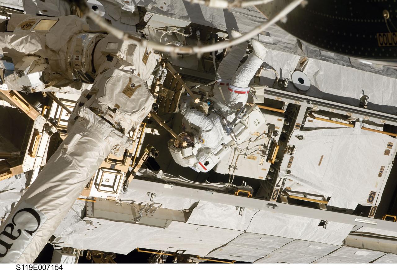 S119-E-007154 (23 March 2009) --- Astronaut Joseph Acaba, STS-119 mission specialist, participates in the mission's third scheduled session of extravehicular activity (EVA) as construction and maintenance continue on the International Space Station. During the six-hour, 27-minute spacewalk, Acaba and Richard Arnold (out of frame), mission specialist, helped robotic arm operators relocate the Crew Equipment Translation Aid (CETA) cart from the Port 1 to Starboard 1 truss segment, installed a new coupler on the CETA cart, lubricated snares on the "B" end of the space station's robotic arm and performed a few "get ahead" tasks.