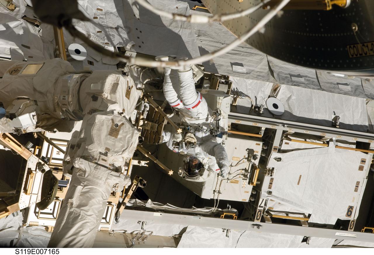 S119-E-007165 (23 March 2009) --- Astronaut Joseph Acaba, STS-119 mission specialist, participates in the mission's third scheduled session of extravehicular activity (EVA) as construction and maintenance continue on the International Space Station. During the six-hour, 27-minute spacewalk, Acaba and Richard Arnold (out of frame), mission specialist, helped robotic arm operators relocate the Crew Equipment Translation Aid (CETA) cart from the Port 1 to Starboard 1 truss segment, installed a new coupler on the CETA cart, lubricated snares on the "B" end of the space station's robotic arm and performed a few "get ahead" tasks.
