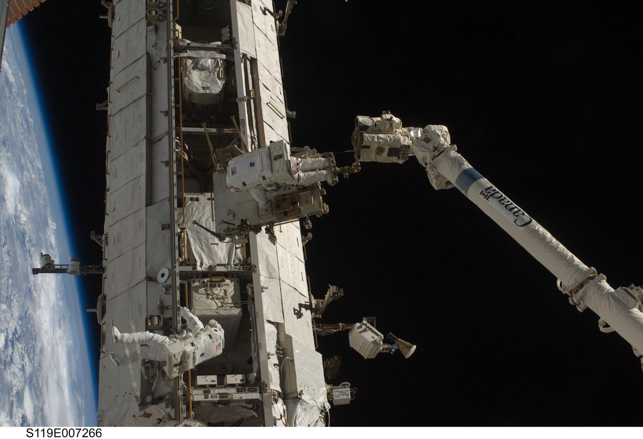 S119-E-007266 (23 March 2009) --- Astronauts Richard Arnold (bottom) and Joseph Acaba, both STS-119 mission specialists, participate in the mission's third scheduled session of extravehicular activity (EVA) as construction and maintenance continue on the International Space Station. During the six-hour, 27-minute spacewalk, Arnold and Acaba helped robotic arm operators relocate the Crew Equipment Translation Aid (CETA) cart from the Port 1 to Starboard 1 truss segment, installed a new coupler on the CETA cart, lubricated snares on the "B" end of the space station's robotic arm and performed a few "get ahead" tasks.