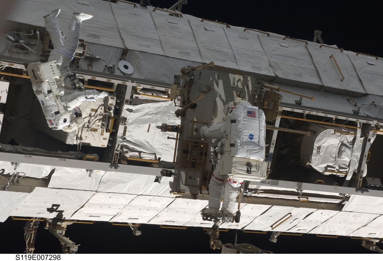 S119-E-007298 (23 March 2009) --- Astronauts Richard Arnold (left) and Joseph Acaba, both STS-119 mission specialists, participate in the mission's third scheduled session of extravehicular activity (EVA) as construction and maintenance continue on the International Space Station. During the six-hour, 27-minute spacewalk, Arnold and Acaba helped robotic arm operators relocate the Crew Equipment Translation Aid (CETA) cart from the Port 1 to Starboard 1 truss segment, installed a new coupler on the CETA cart, lubricated snares on the "B" end of the space station's robotic arm and performed a few "get ahead" tasks.