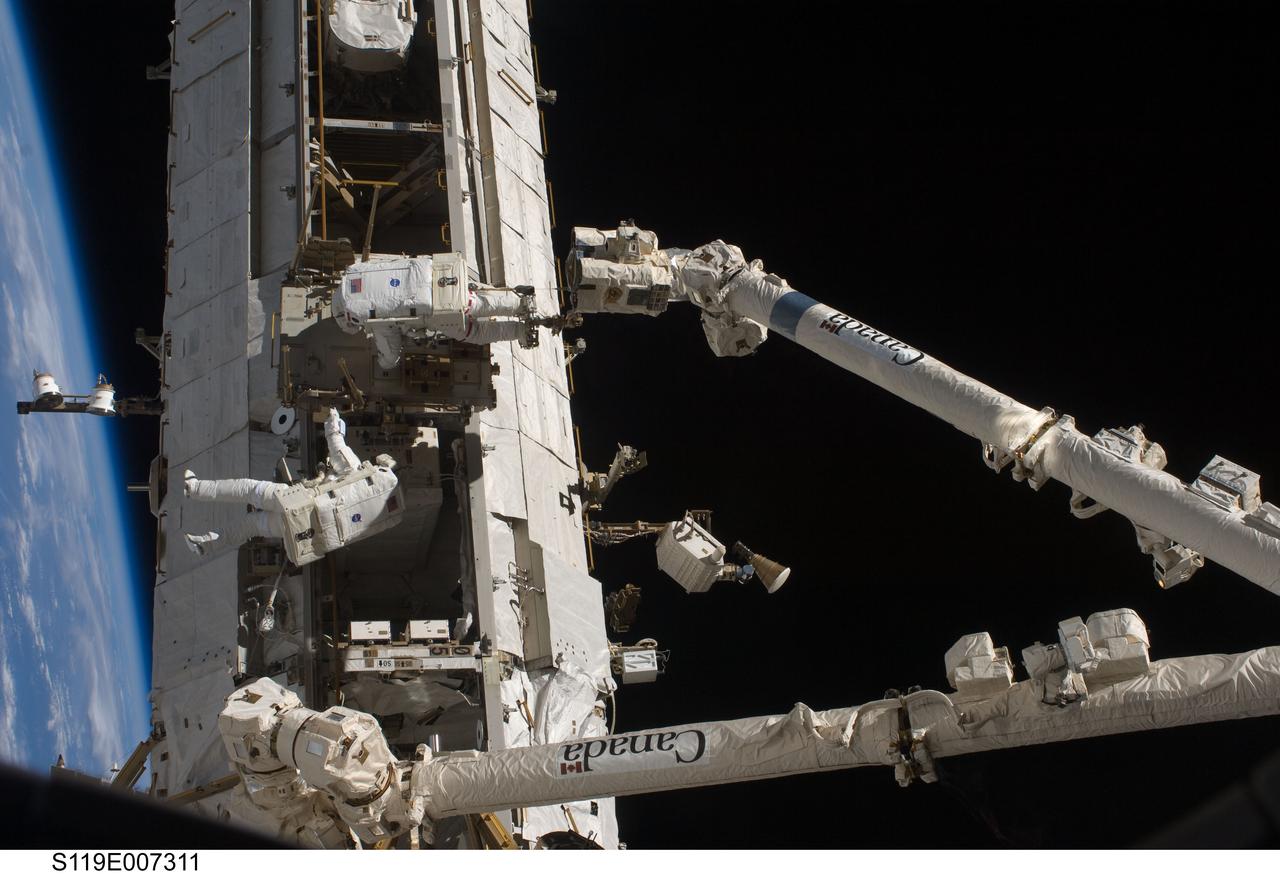 S119-E-007311 (23 March 2009) --- Astronauts Richard Arnold (bottom) and Joseph Acaba, both STS-119 mission specialists, participate in the mission's third scheduled session of extravehicular activity (EVA) as construction and maintenance continue on the International Space Station. During the six-hour, 27-minute spacewalk, Arnold and Acaba helped robotic arm operators relocate the Crew Equipment Translation Aid (CETA) cart from the Port 1 to Starboard 1 truss segment, installed a new coupler on the CETA cart, lubricated snares on the "B" end of the space station's robotic arm and performed a few "get ahead" tasks.