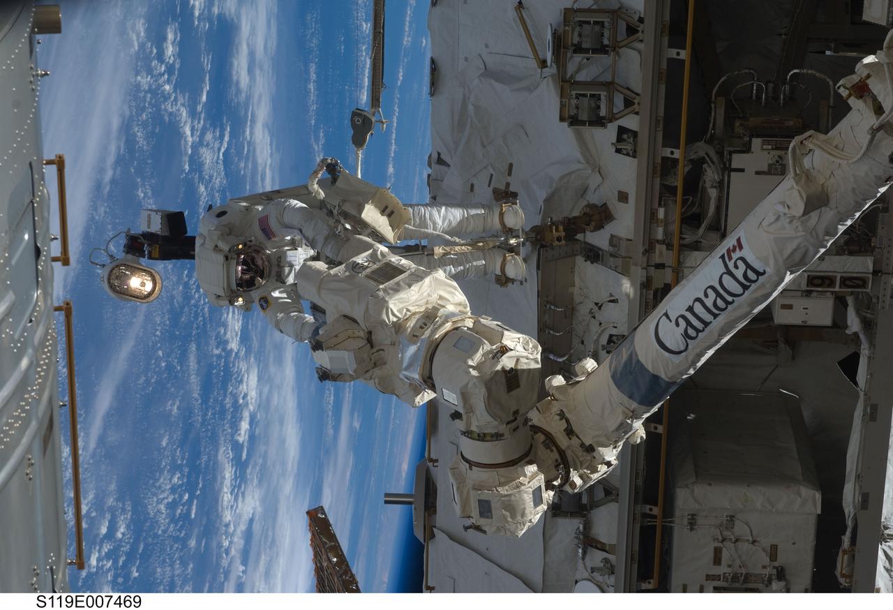 S119-E-007469 (23 March 2009) --- Astronaut Richard Arnold, STS-119 mission specialist, participates in the mission's third scheduled session of extravehicular activity (EVA) as construction and maintenance continue on the International Space Station. During the six-hour, 27-minute spacewalk, Arnold and Joseph Acaba (out of frame), mission specialist, helped robotic arm operators relocate the Crew Equipment Translation Aid (CETA) cart from the Port 1 to Starboard 1 truss segment, installed a new coupler on the CETA cart, lubricated snares on the "B" end of the space station's robotic arm and performed a few "get ahead" tasks.