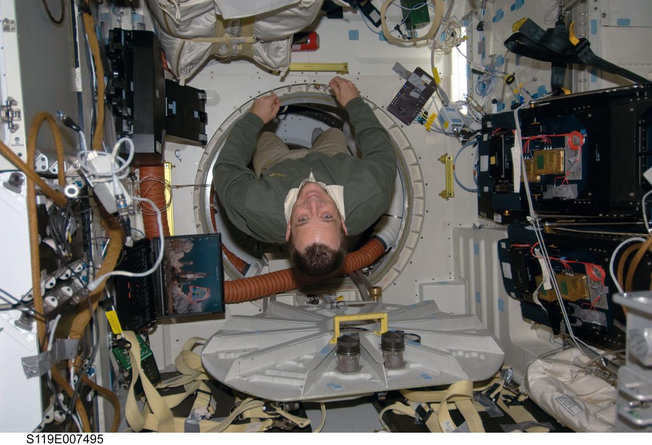 S119-E-007495 (22 March 2009) --- Astronaut Richard Arnold, STS-119 mission specialist, floats on the middeck of Space Shuttle Discovery while docked with the International Space Station.