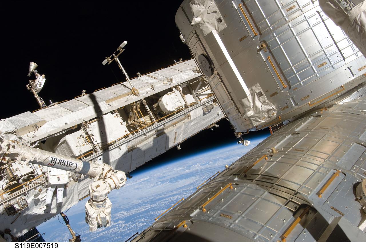 S119-E-007519 (23 March 2009) --- Astronaut Richard Arnold (lower left on port truss), STS-119 mission specialist, participates in the mission's third scheduled session of extravehicular activity (EVA) as construction and maintenance continue on the International Space Station. During the six-hour, 27-minute spacewalk, Arnold and Joseph Acaba (out of frame), mission specialist, helped robotic arm operators relocate the Crew Equipment Translation Aid (CETA) cart from the Port 1 to Starboard 1 truss segment, installed a new coupler on the CETA cart, lubricated snares on the "B" end of the space station's robotic arm and performed a few "get ahead" tasks. The Japanese Kibo laboratory is visible at right, and the station’s Canadarm2 is at left. The blackness of space and Earth’s horizon provide the backdrop for the scene.