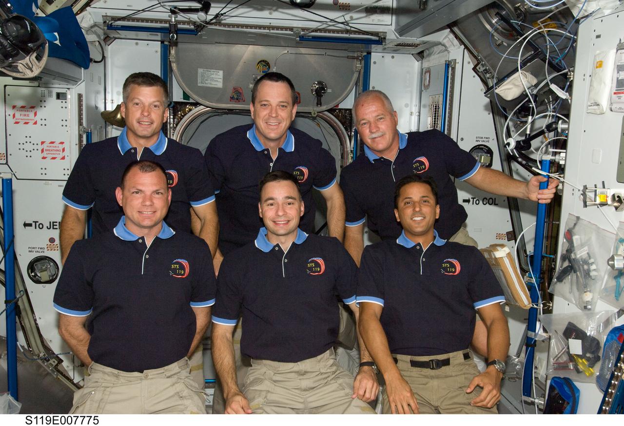 S119-E-007775 (24 March 2009) --- STS-119 crewmembers pose for a group photo following a joint news conference in the Harmony node of the International Space Station while Space Shuttle Discovery remains docked with the station. From the left (bottom row) are NASA astronauts Tony Antonelli, pilot; Lee Archambault, commander; and Joseph Acaba, mission specialist. From the left (top row) are astronauts Steve Swanson, Richard Arnold and John Phillips, all mission specialists.
