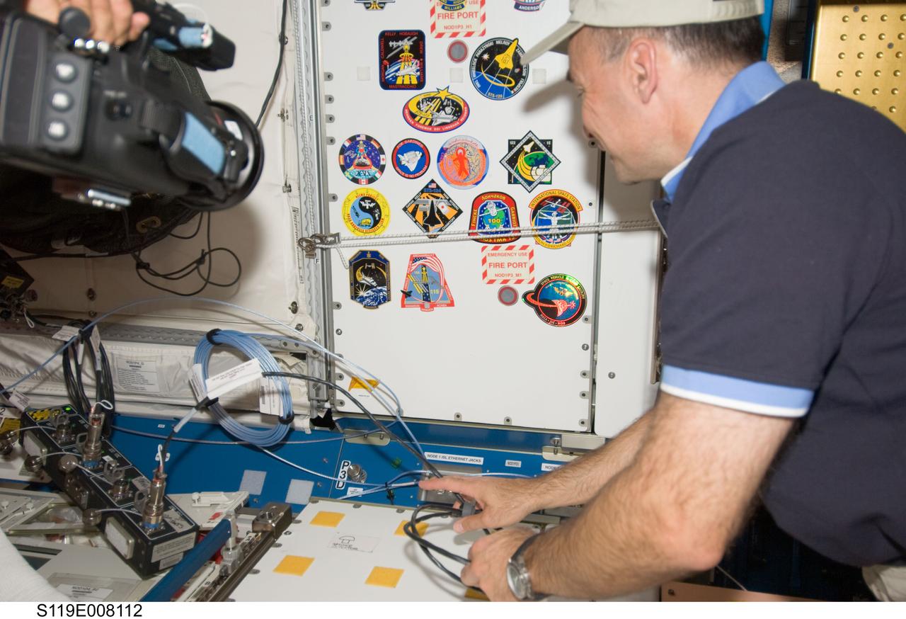 S119-E-008112 (24 March 2009) --- Astronaut Lee Archambault, STS-119 commander, is pictured after adding his crew patch in the Unity node to the growing collection of those representing shuttle crews who have worked on the International Space Station.