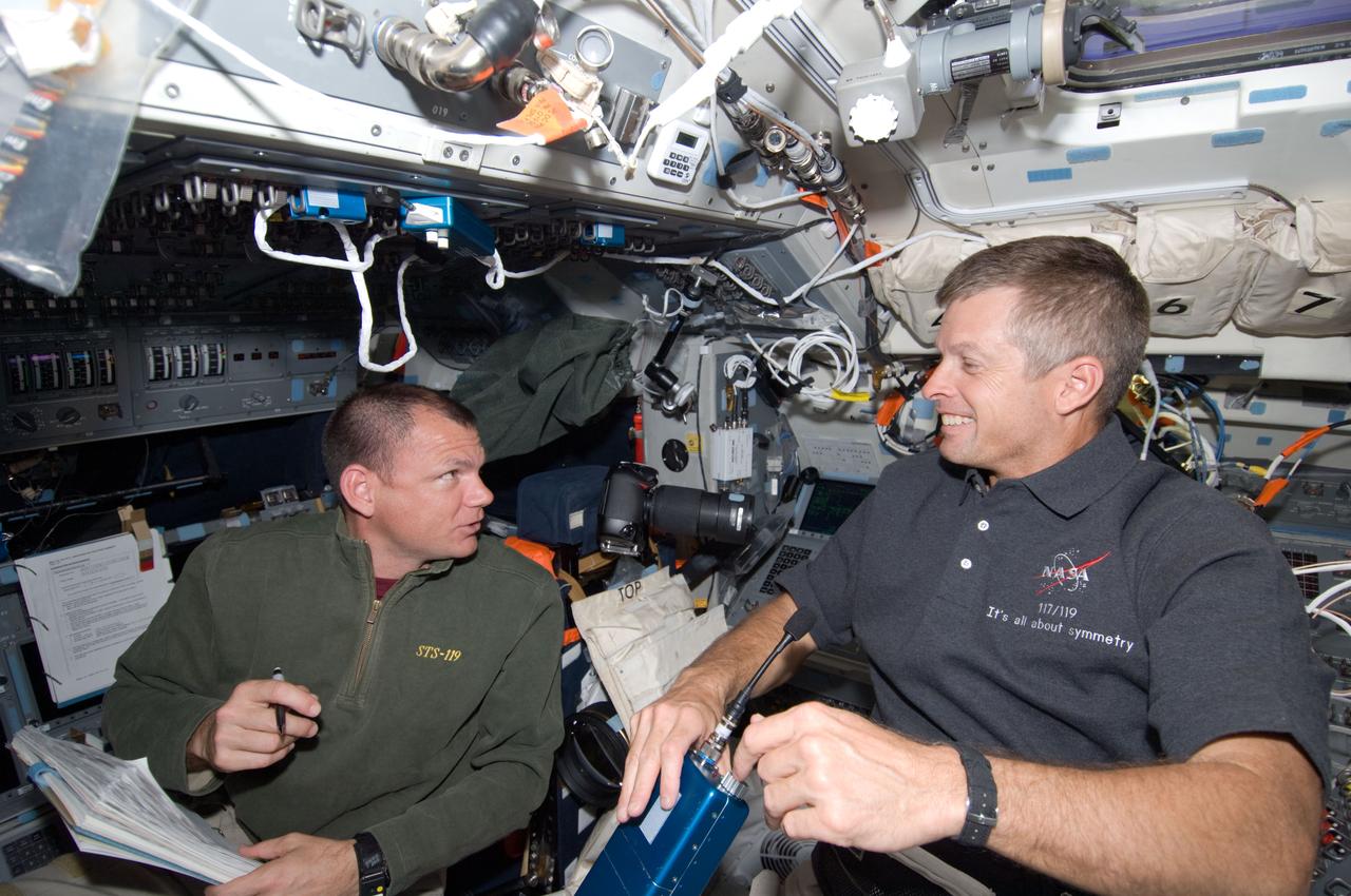 S119-E-008161 (25 March 2009) --- Astronauts Tony Antonelli (left), STS-119 pilot; and Steve Swanson, mission specialist, are pictured on the flight deck of Space Shuttle Discovery during flight day 11 activities.