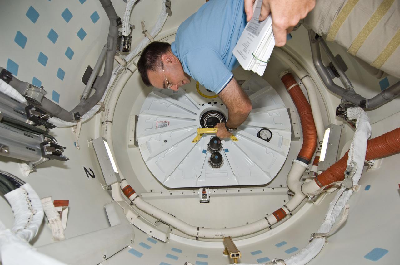 S119-E-008429 (25 March 2009) --- Astronaut Lee Archambault, STS-119 commander, closes the hatch on the middeck of Space Shuttle Discovery prior to undocking from the International Space Station to conclude almost 10 days of cooperative work onboard the shuttle and the station. Undocking of the two spacecraft occurred at 2:53 p.m. (CDT) on March 25, 2009.