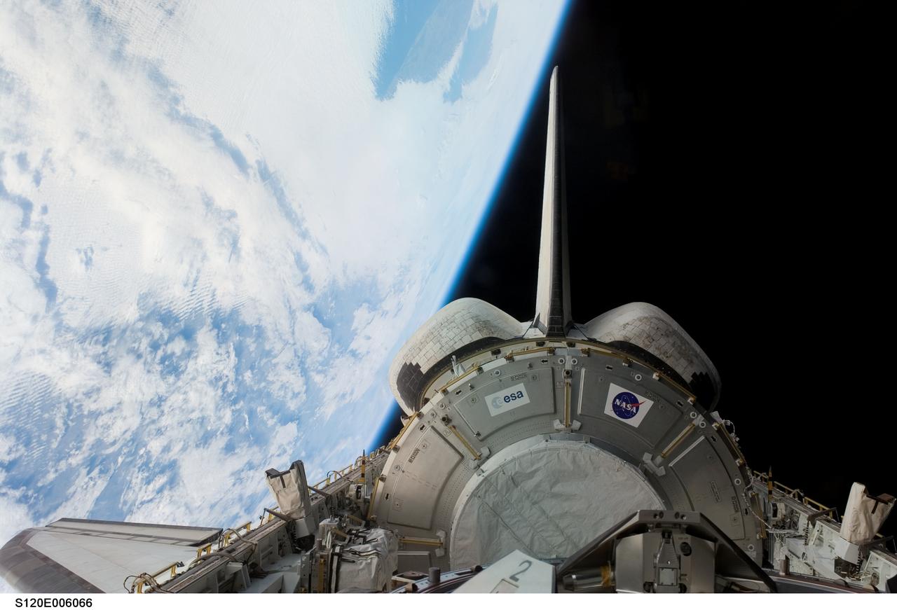 S120-E-006066 (24 Oct. 2007) --- Backdropped by the blackness of space and Earth's horizon, the Harmony node in Space Shuttle Discovery's payload bay, vertical stabilizer and orbital maneuvering system (OMS) pods are featured in this image photographed by a STS-120 crewmember during flight day two activities.