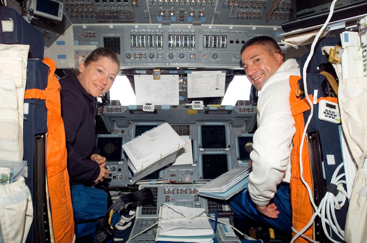 S120-E-006171 (25 Oct. 2007) --- Astronauts Pam Melroy and George Zamka, STS-120 commander and pilot, respectively, take a moment for a photo while working at their stations on the flight deck of Space Shuttle Discovery during flight day three activities.