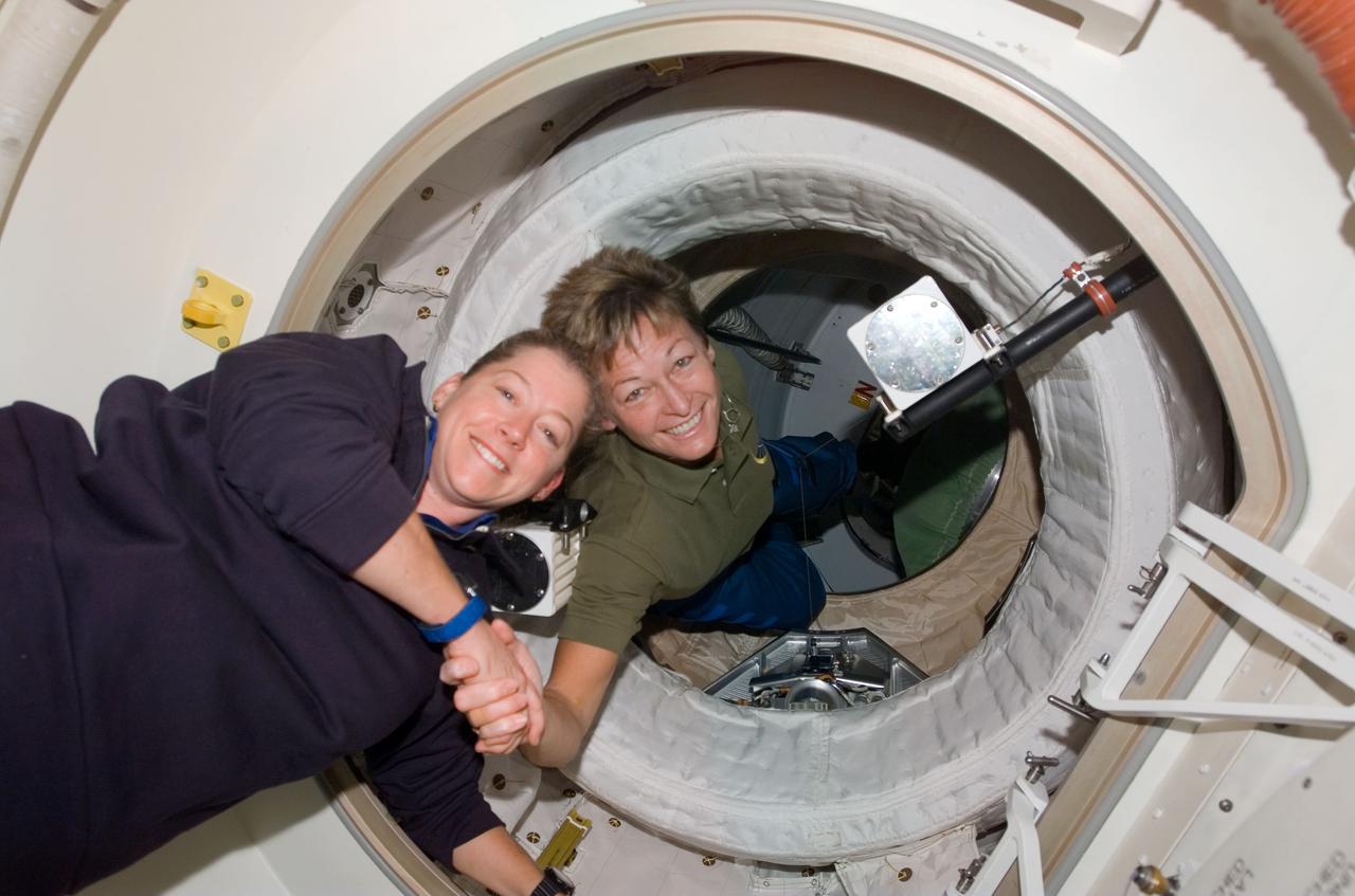 S120-E-006397 (25 Oct. 2007) --- Astronaut Peggy Whitson (right), Expedition 16 commander, greets astronaut Pam Melroy, STS-120 commander, after hatch opening between the International Space Station and Space Shuttle Discovery. Whitson is partially in the Pressurized Mating Adapter (PMA-2) and Melroy is in the Orbiter Docking Compartment (ODC).