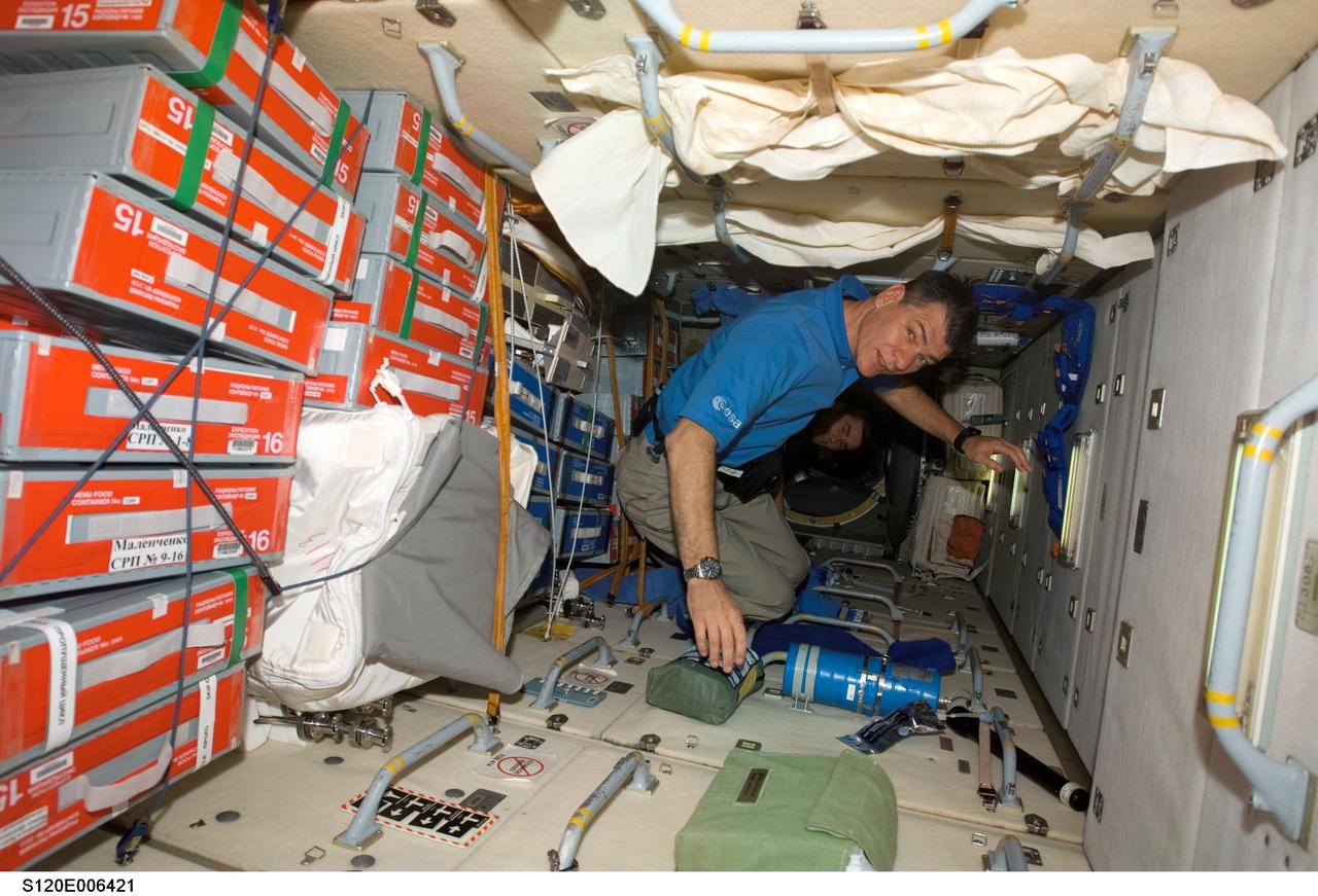S120-E-006421 (25 Oct. 2007) --- European Space Agency (ESA) astronaut Paolo Nespoli, STS-120 mission specialist, photographed in the Zarya module of the International Space Station while Space Shuttle Discovery is docked with the station. Various food stowage cases are visible at left.